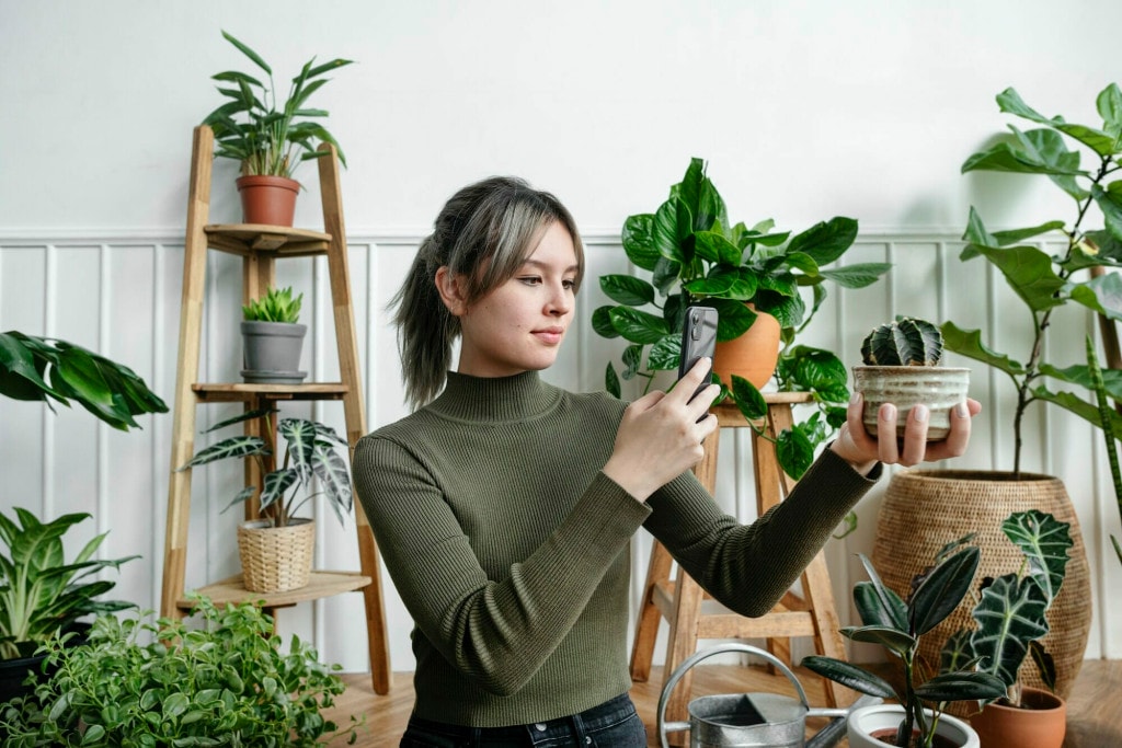 Woman taking a snapshot of her product plant for social media